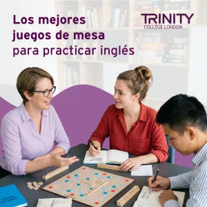 Profesora y dos estudiantes juegan a un juego de mesa mientras practican inglés en un entorno educativo.